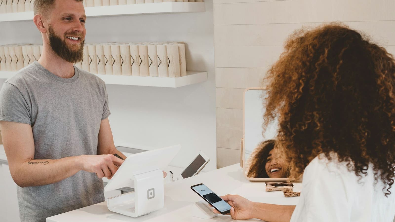 A shop owner at a counter serving a customer, the kind of vendor a multi-vendor marketplace is built for